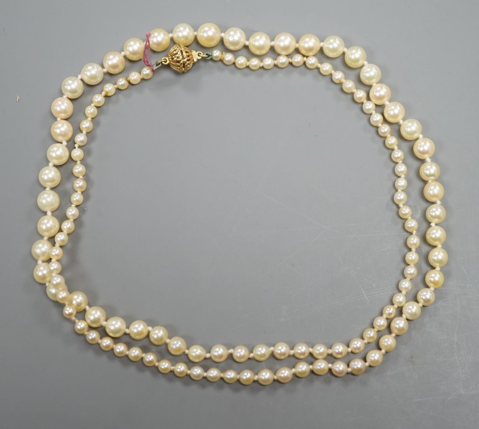 A singe strand graduated cultured pearl necklace with yellow metal clasp, 64cm, gross weight 20.3 grams.